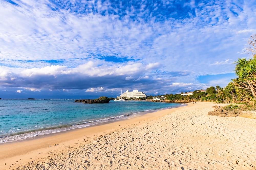 Mr.KINJO in front of Manza Beach Featured Image